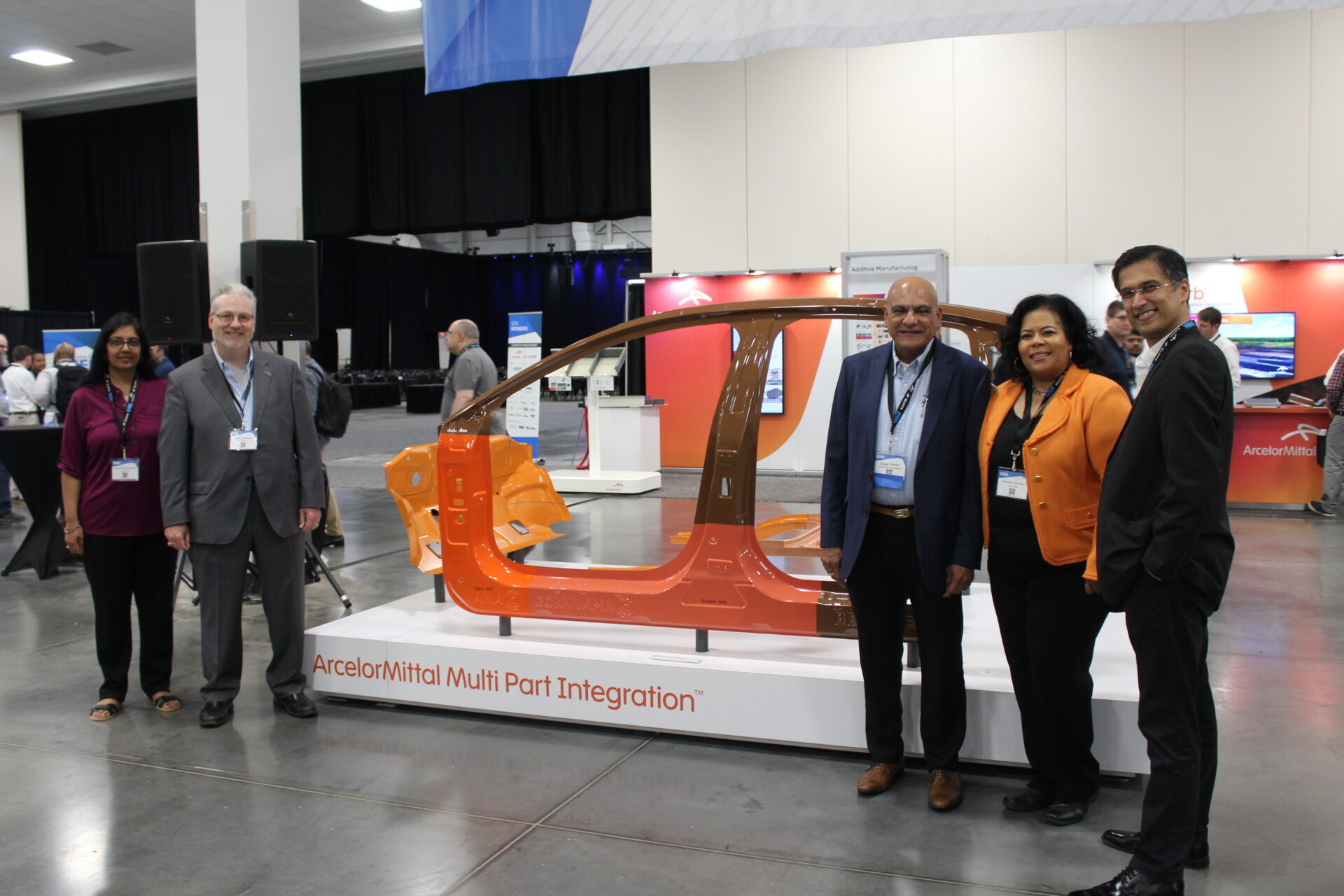GDIS sponsors and attendees posing in front of a car frame